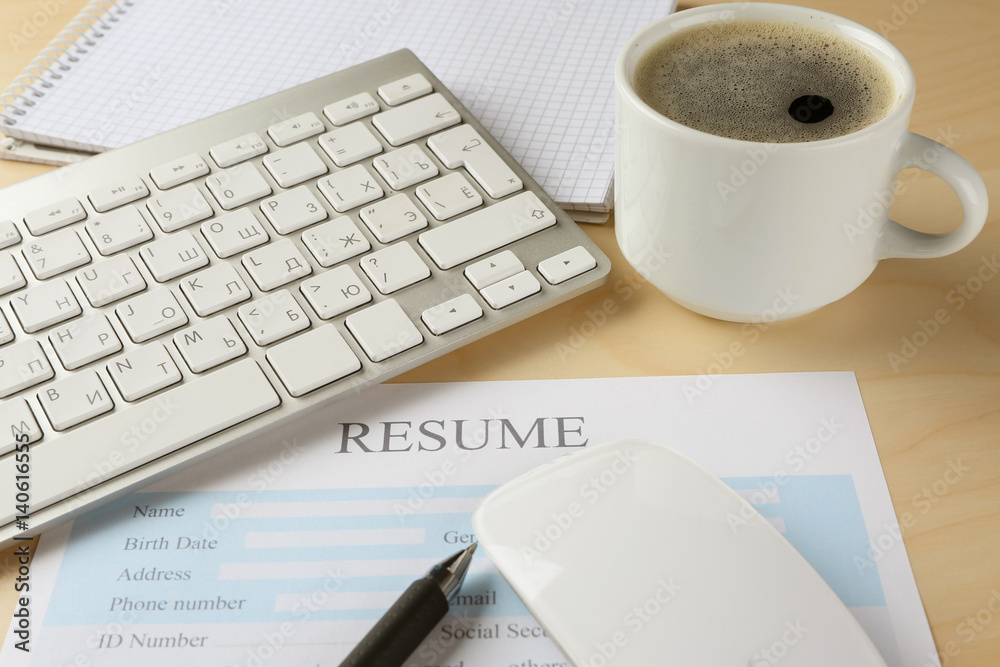 Resume form, keyboard and cup of coffee on wooden table, closeup Resume form, keyboard and cup of coffee on wooden table, closeup
