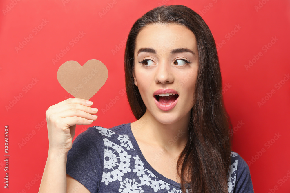 Beautiful young woman with paper heart on color background Beautiful young woman with paper heart on color background