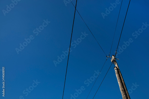 Low angle view of electric wires against clear blue sky