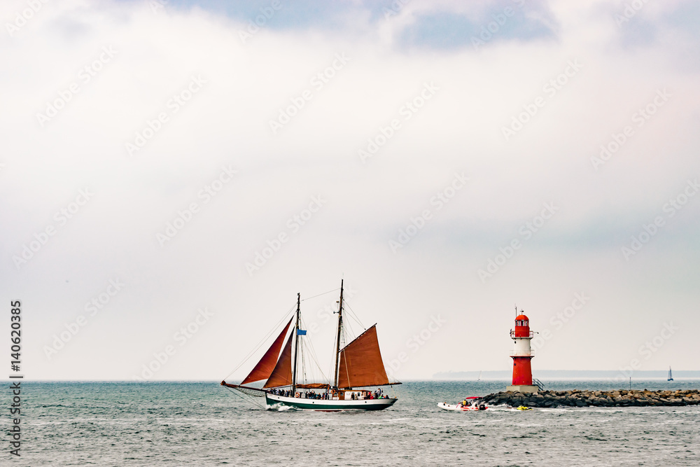 Naklejka premium Sailing ships on the sea. Tall Ship and lighthouse Yachting travel.