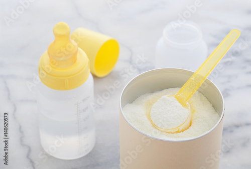 Milchpulver in einem Messlöffel Zubereitung von Babynahrung and Wasser in Flasche