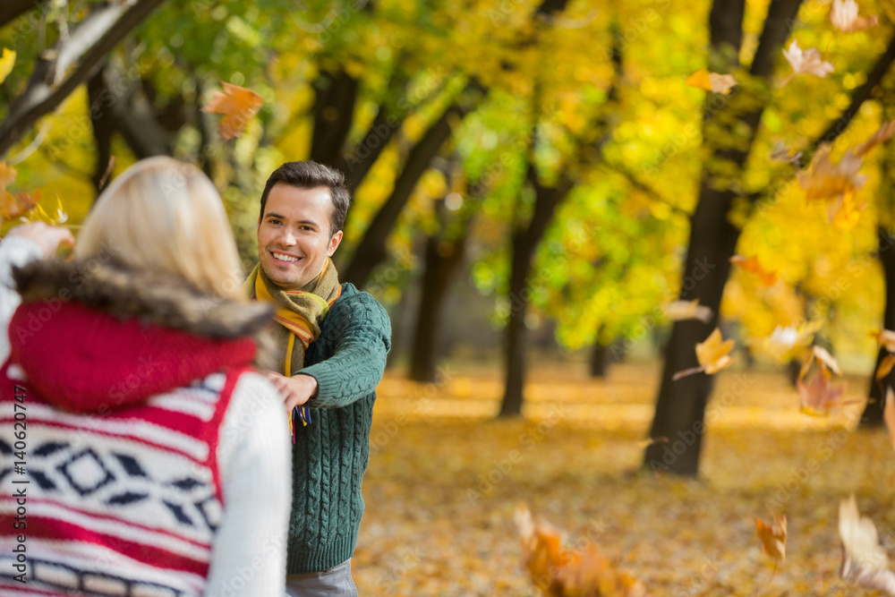 Happy couple playing with autumn leaves in park Happy couple playing with autumn leaves in park