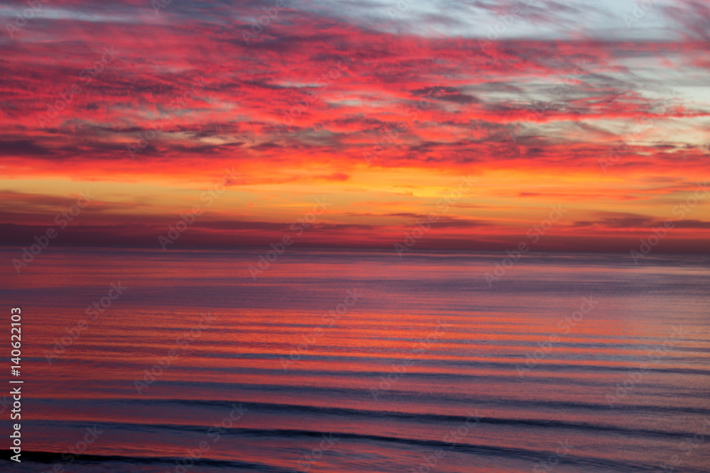 Fototapeta premium огненное небо отражается на поверхности воды