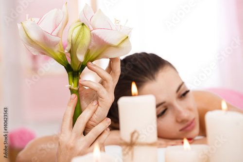 Valokuva Closeup of young woman relaxing after back massage admiring atmosphere