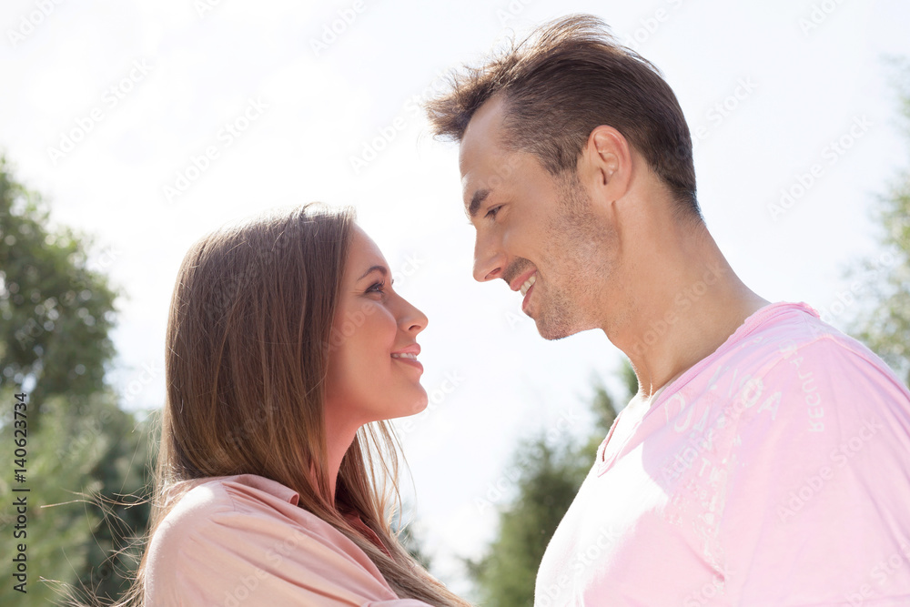 Side view of affectionate young couple looking at each other in park Side view of affectionate young couple looking at each other in park