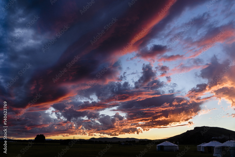 Sunset in a Mongolian yurt camp, showing a burning sky with brightly red and orange colored clouds