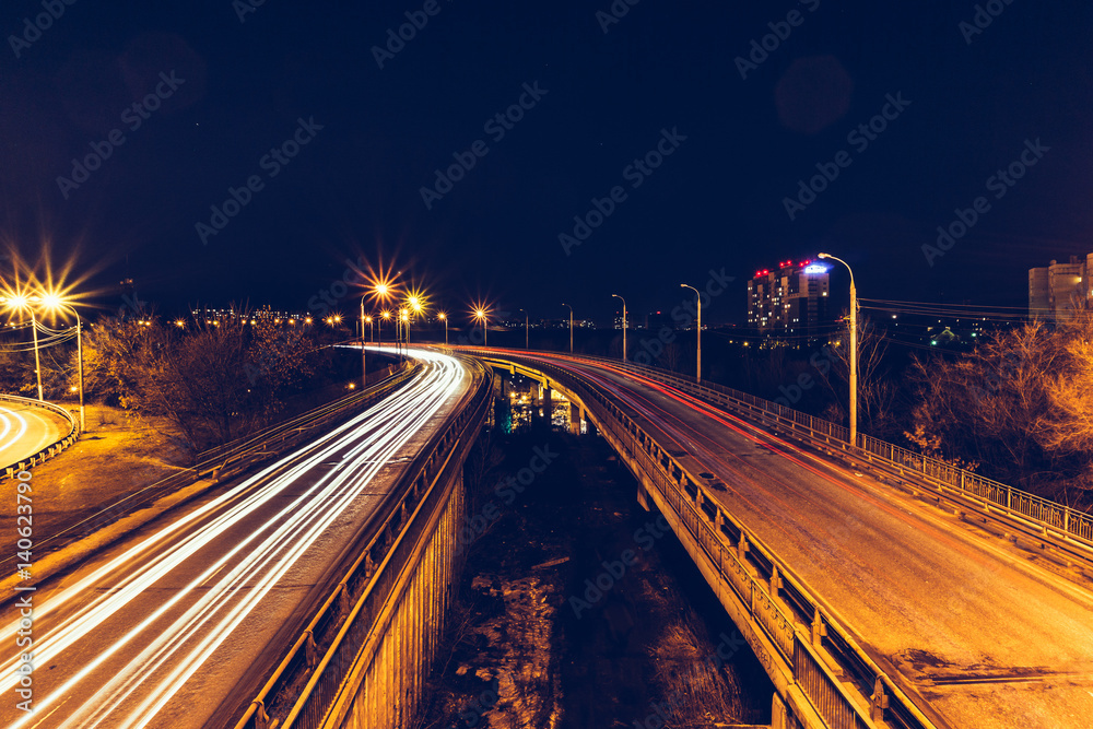 Bridge, curve road, night city landscape, freezelight car lights, long exposure,