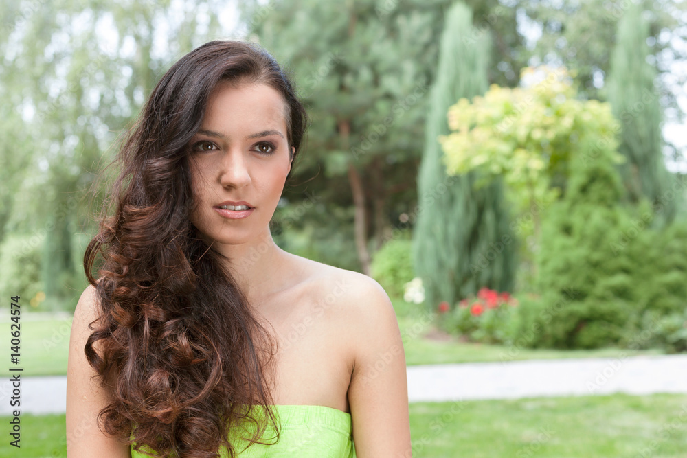 Beautiful young woman with long wavy hair in park Beautiful young woman with long wavy hair in park