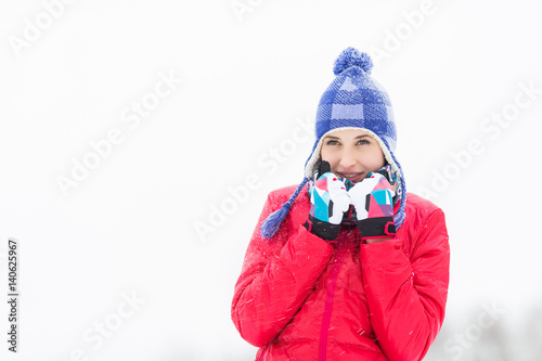 Beautiful young woman in warm clothing walking outdoors
