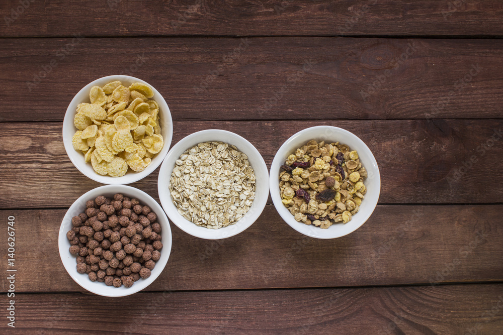 Different cereal breakfast in white bowl on wooden background Different cereal breakfast in white bowl on wooden background