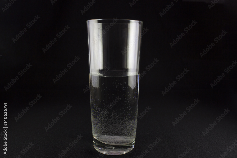 glass of water with bubbles on dark background glass of water with bubbles on dark background