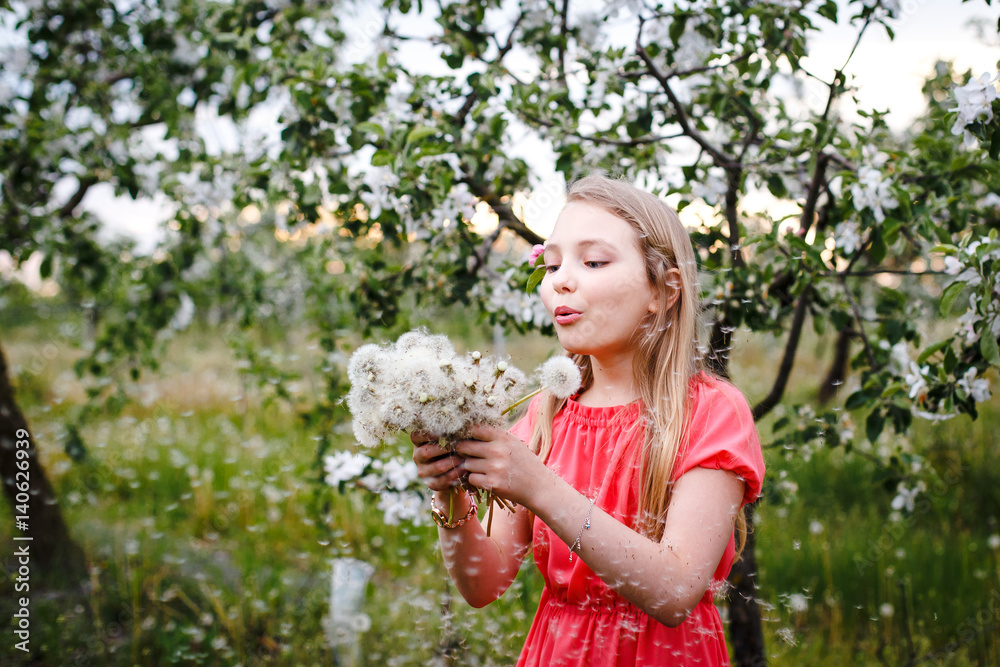 Cute little girl with bunch of lilac near apple trees in blossom at sunset. Kid enjoying happy childhood. Family, love, peace and happiness concept Cute little girl with bunch of lilac near apple trees in blossom at sunset. Kid enjoying happy childhood. Family, love, peace and happiness concept
