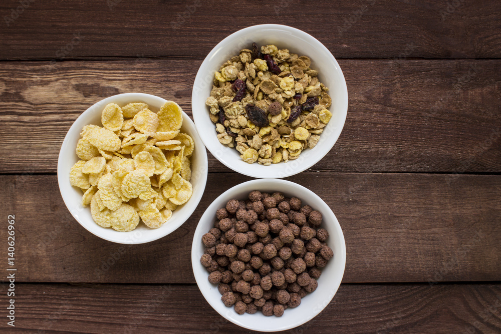 Three bowls of cereals on wooden table Three bowls of cereals on wooden table