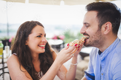 Couple sharing a slice of pizza outdoor