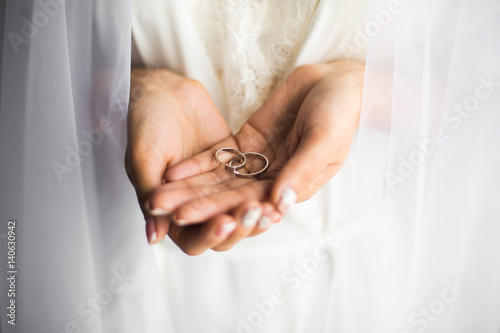 Wedding rings in the hands of the bride.