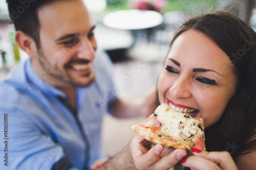 Couple sharing a slice of pizza outdoor