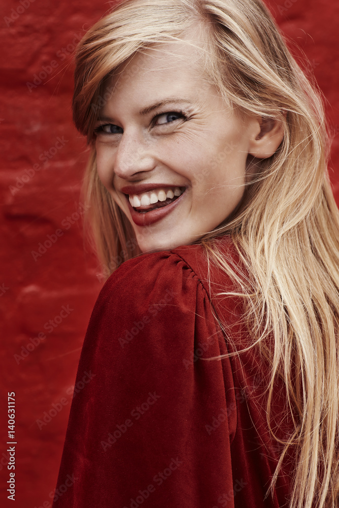Fototapeta premium Stunning blond smiling in red dress, close up
