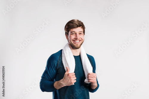 Handsome fitness man resting after working out, towel around nec