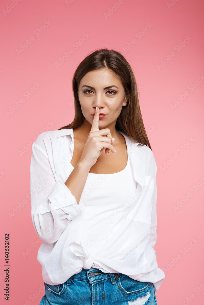 Pretty girl in summer look asks for silence looking straight Pretty girl in summer look asks for silence looking straight