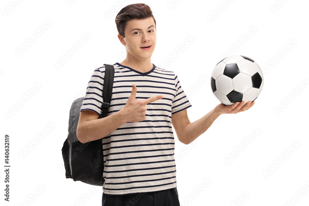 Teen student holding a football and pointing Teen student holding a football and pointing