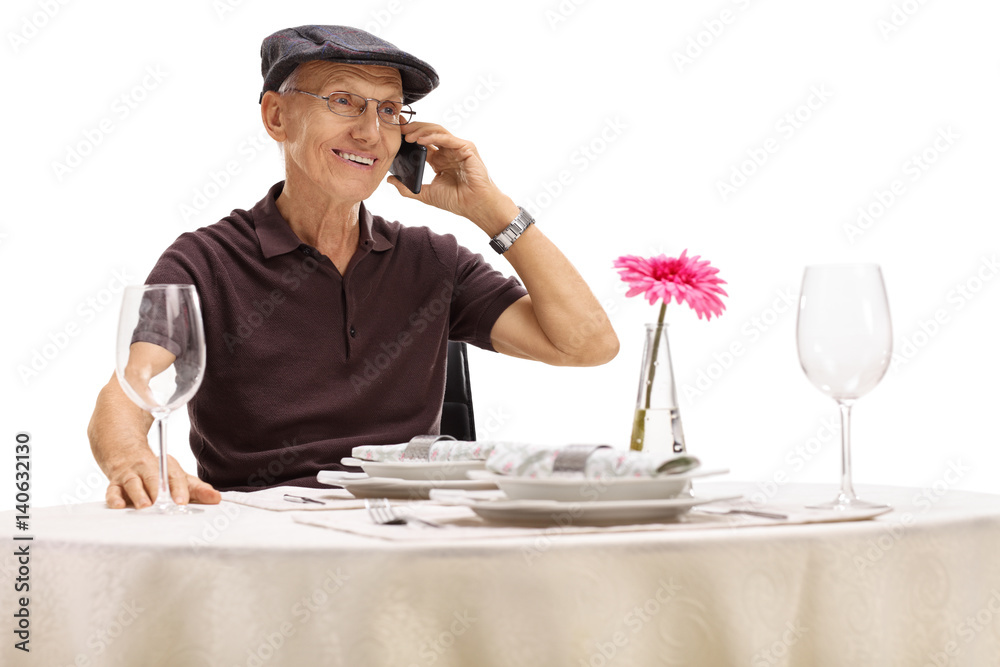 Senior sitting at restaurant table and talking on phone Senior sitting at restaurant table and talking on phone