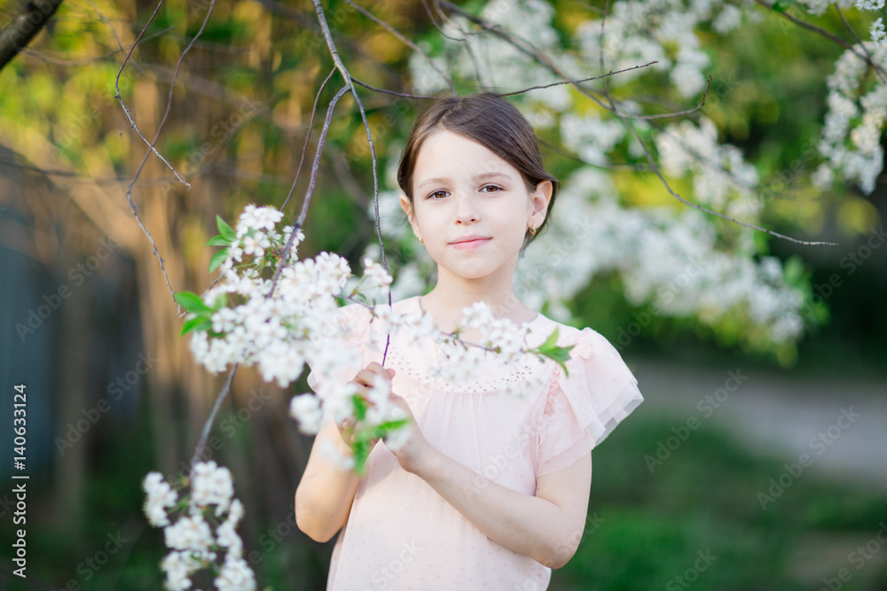 Adorable little girl in blooming apple tree garden. Cute child near apple tree at spring. Adorable little girl in blooming apple tree garden. Cute child near apple tree at spring.