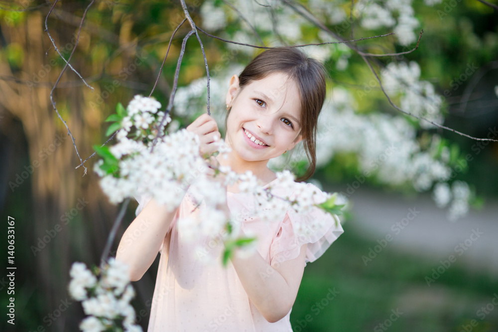 Adorable little girl in blooming apple tree garden. Cute child near apple tree at spring. Adorable little girl in blooming apple tree garden. Cute child near apple tree at spring.
