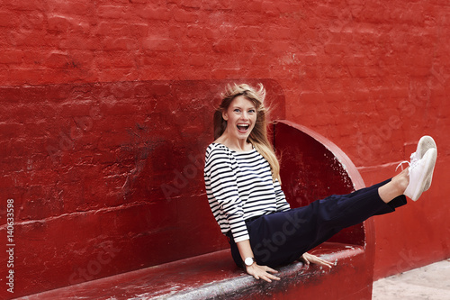 Photography Ecstatic blond woman on red bench, portrait