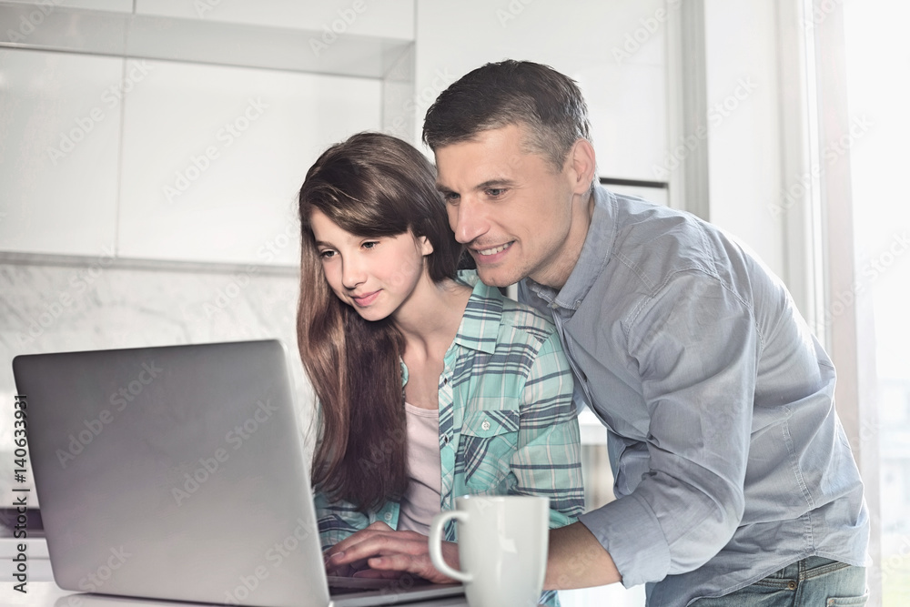 Father and daughter using laptop at home Father and daughter using laptop at home