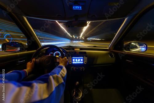 Night road view from inside car natural light street and other cars is motion blurred