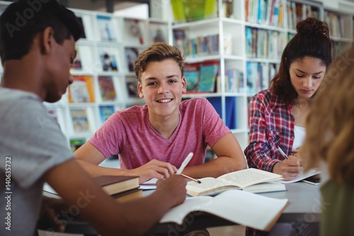happy schoolboy studying with his classmates  photo