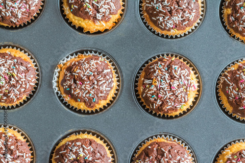 Baked sweet decorated muffins in tin form