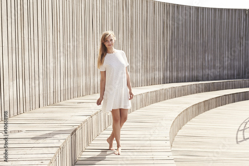 Smiling sunlit babe in white dress, portrait
