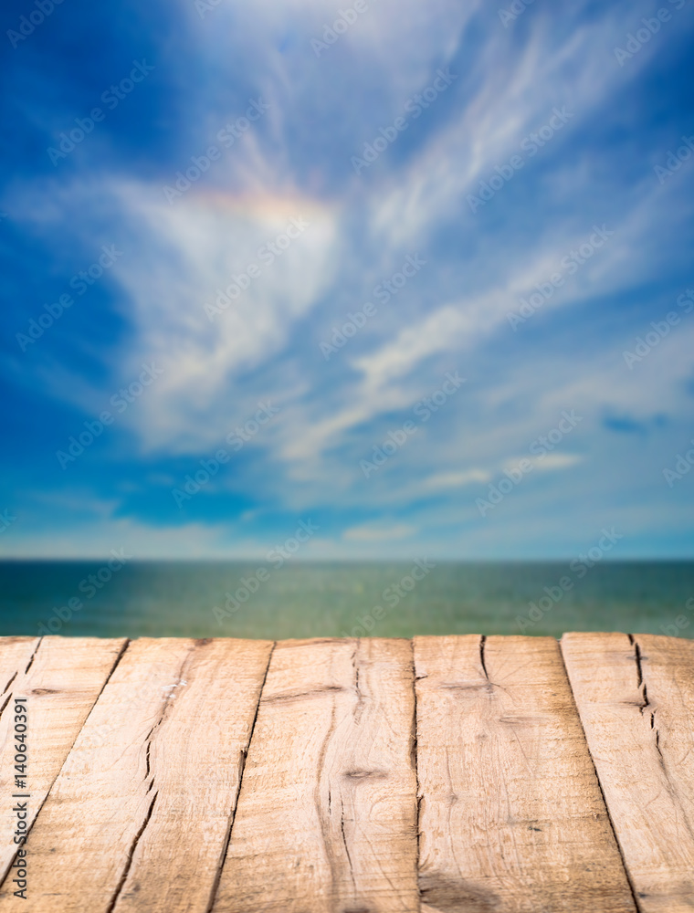 Empty plank wooden surface in front of blurred sky with ocean water
