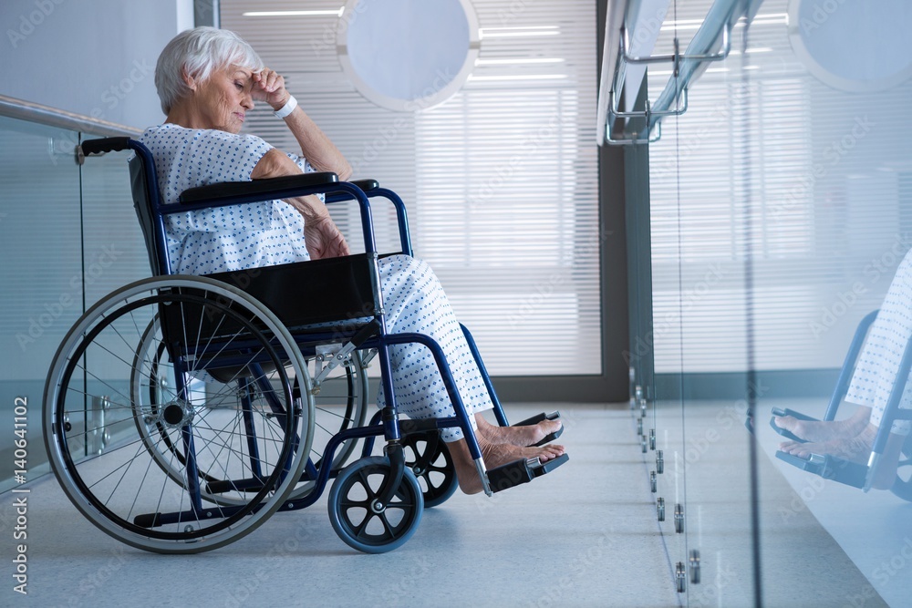 Disabled senior patient on wheelchair in hospital passageway Disabled senior patient on wheelchair in hospital passageway