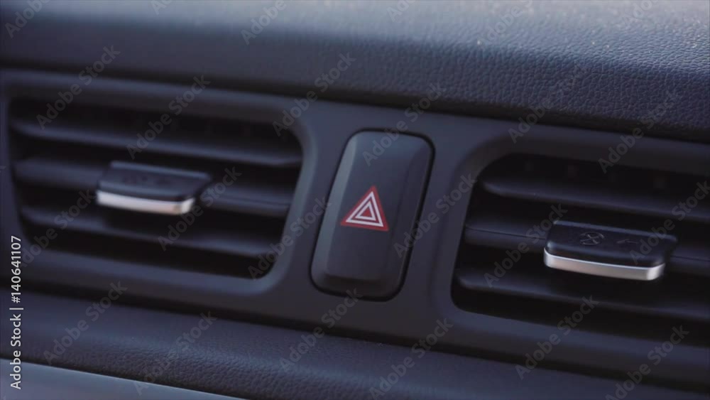 A man's hand presses the emergency button in the car. A man's hand presses the emergency button in the car.