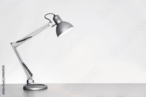 фотографія Desk lamp on table over white background
