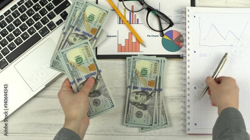 Man counts the money and writes in notebook