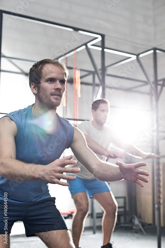 Determined men exercising at crossfit gym