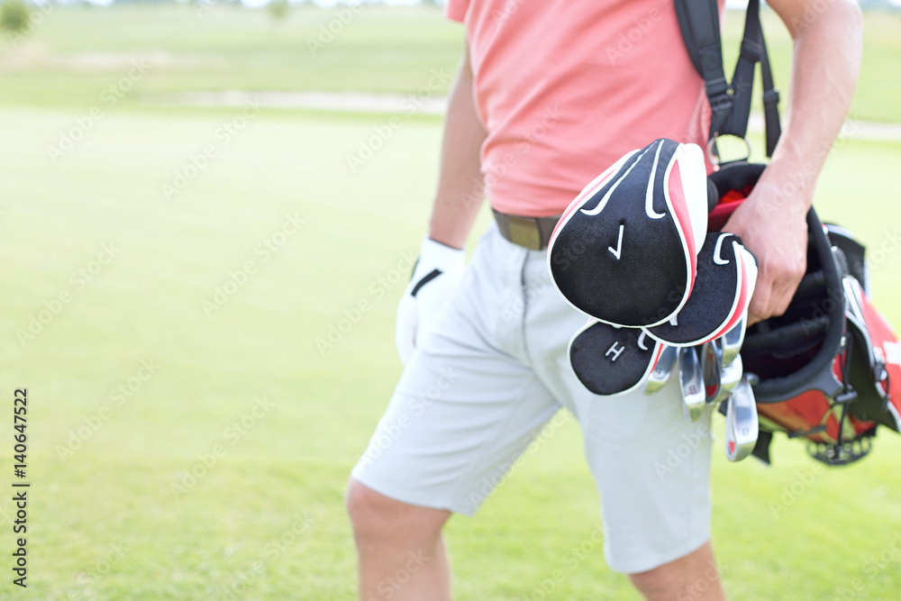 Fototapeta premium Midsection of man carrying golf club bag at course