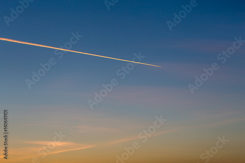 Jet plane leaves contrail in a sunset beautiful  sky  copy space for text
