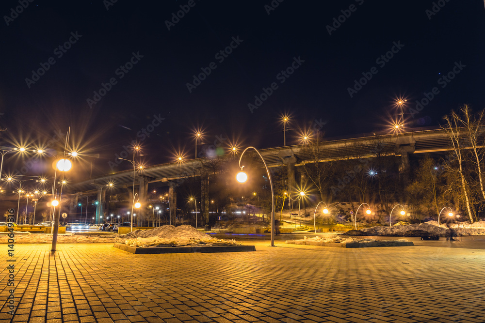 Night view of the bridge and parking near the entrance to the park Dynamo