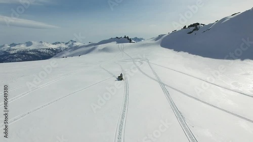 Men on snowmobile in winter mountain photo