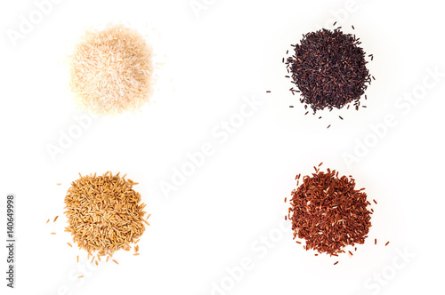 Heap of four different kind of rice. Jasmine white, brown, black and unpolished raw rice on white background