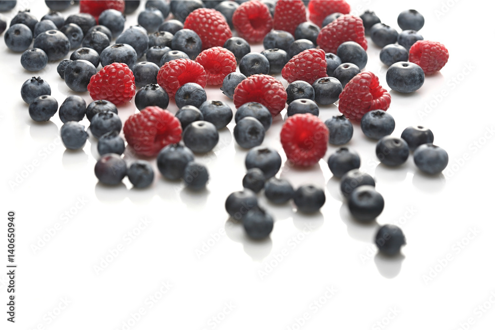 Raspberries and blueberries on white background