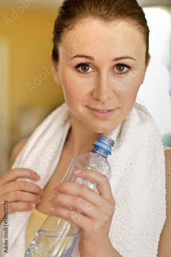 A young woman drinking a bottle of water