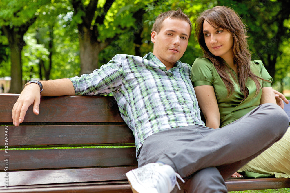 Fototapeta premium Young couple sitting on bench