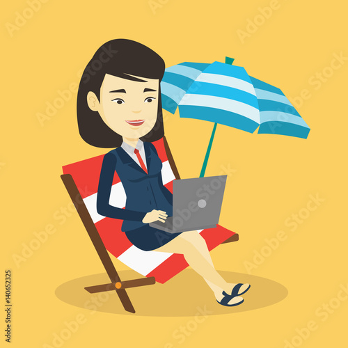 Business woman working on laptop at the beach.