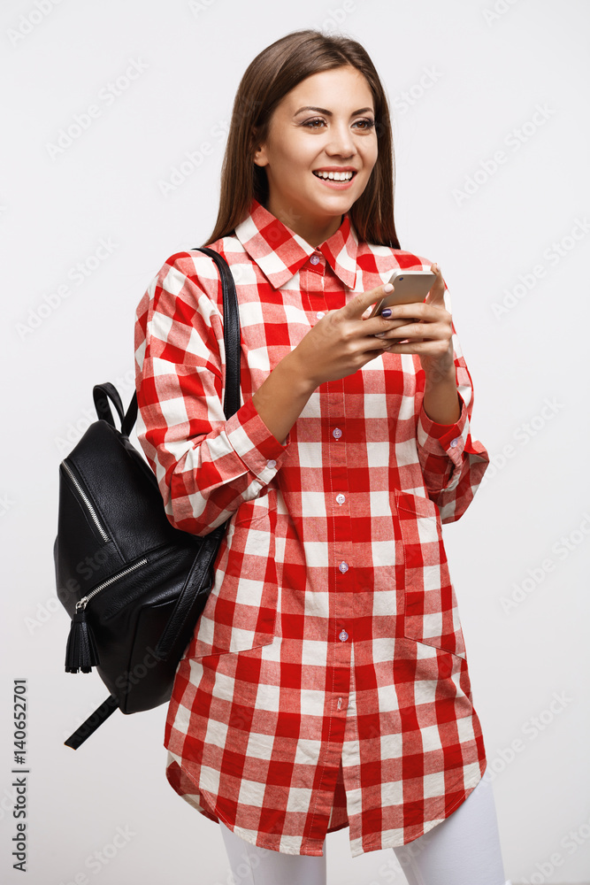 Girl in casual texting friends looking away smiling happily Girl in casual texting friends looking away smiling happily