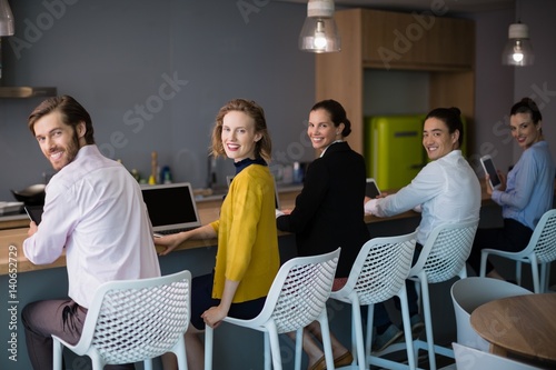 Business executives using electronic devices on conference table